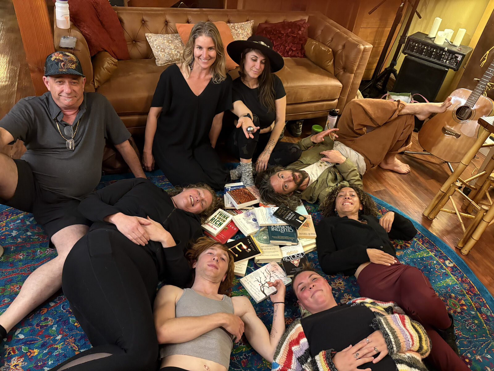 Oscura Book Club members gathered on a rug surrounded by books