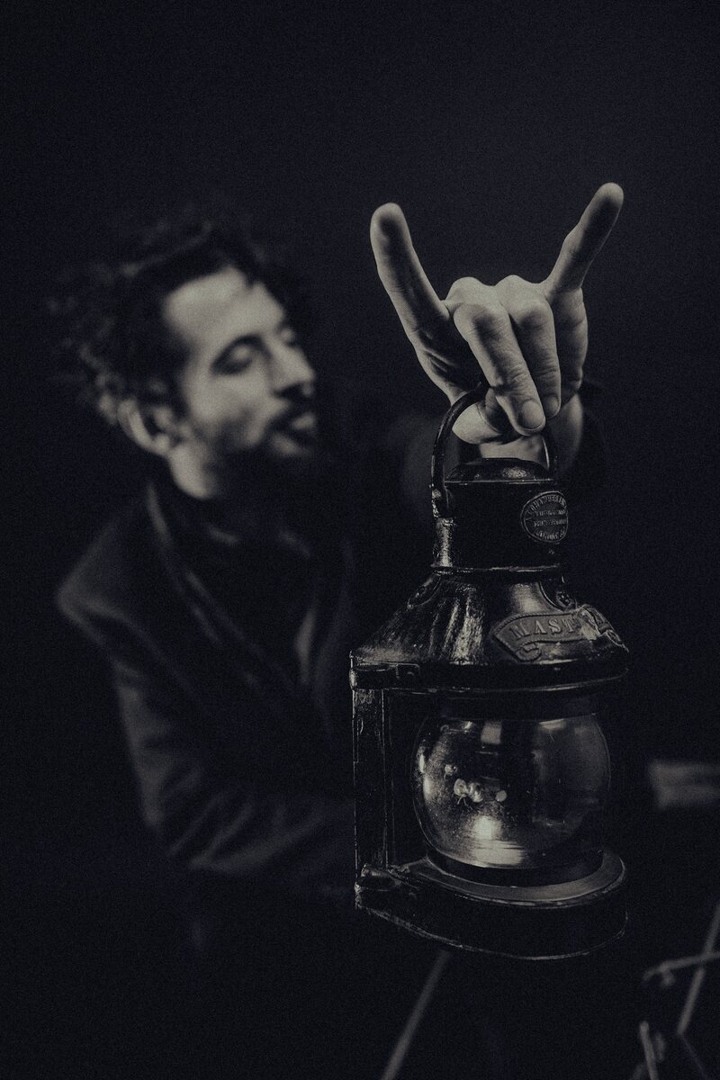 Travis Puntarelli holding a lantern, giving the horns hand sign